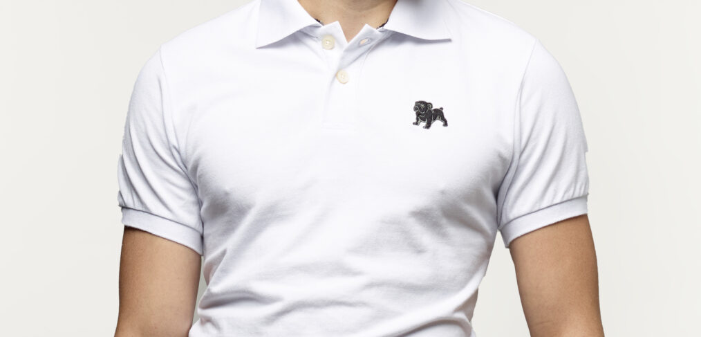Young man wearing a Bulldog Factory polo shirt featuring an embroidered bulldog logo